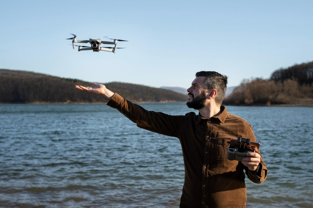 Homem pilotando um drone em um lago